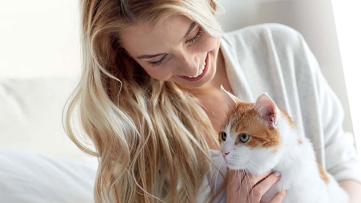 Lady holds orange and white cat